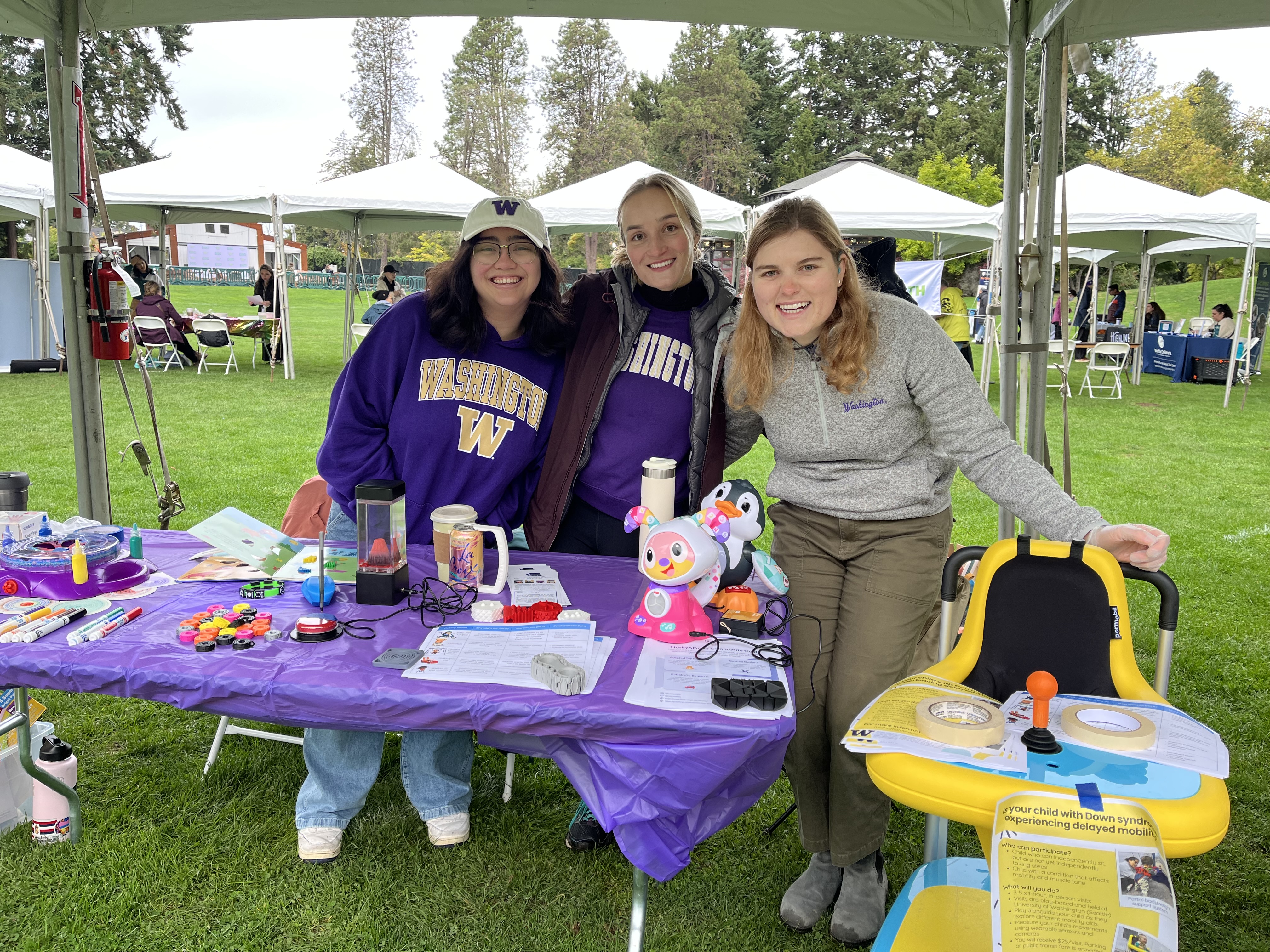 Mia and two students tabling an informational booth at the Puget Sound Buddy Walk.