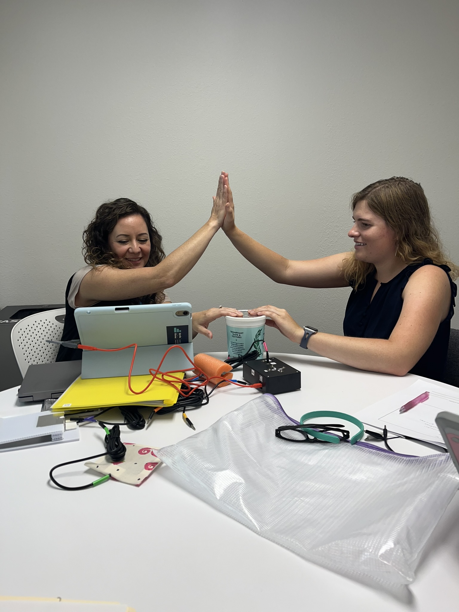 Mia giving a high five to a clinician to activate the conductivity switch on the Switch Kit.