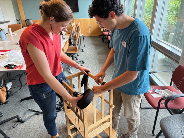 Mia and Spencer working to adapt  a kitchen stool